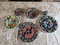 Group shot of all seven pieces: six plates/saucer and espresso cup