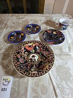 Entire five-piece set: large charger plate, three small plates, one mug on table