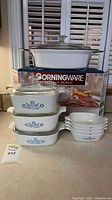 Complete set stacked: three casseroles with lids, four petite pans, boxed French White roaster