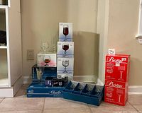 Stacked boxed stemware sets, Claudia and Prestige brands, along with other boxed goblets