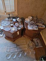 Overall view of both tables with crystal, glass and silver-plated items including additional bowls and trays on floor