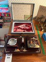 Full view of cloisonné plate in case above lacquer smoking set