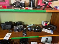 Shelf view showing Olympus 35 ED, XA, Stylus Epic cameras, A11 flash, HOYA filter and accessories