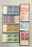 Front view of all seven stamp plate blocks in mounts