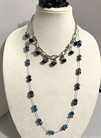 Two necklaces layered on bust; stretch bracelet shown at top