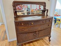 Full view of oak buffet sideboard showing mirror, drawers, cabinet doors, legs