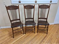 Front view of three wooden pressback chairs