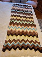 Full view of the crocheted chevron afghan laid flat