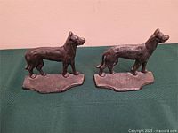 Two matching cast metal dog figures on bases