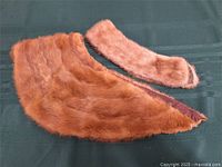 both mink fur collars laid flat on green fabric