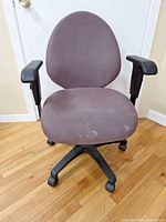 Front view of burgundy office chair showing seat, backrest, casters