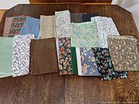 Full lot of assorted fabric pieces laid out on table