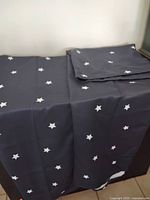 Curtain panel draped and second panel folded showing star pattern