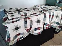 Full view of quilt draped over surface showing overall pattern and two shams