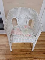 Full view of white wicker armchair with cushion