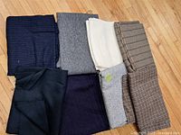 Eight folded fabric lengths laid out on floor showing variety of colours and patterns