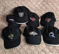 All seven black NFL logo caps laid out showing logos