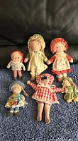 All six vintage rag dolls arranged together on carpet