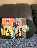Front jacket and vinyl record partially out showing label