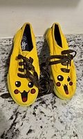 Top view of both yellow Pikachu sneakers with laces visible