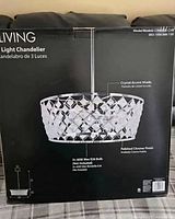 Front of sealed retail box showing chandelier image and specifications