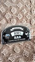 Front of sealed embossed metal Bob’s Bar sign showing graphics and text