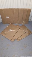 Eight sealed packages of flat kraft boxes displayed