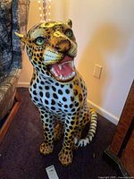 Full view of seated ceramic leopard statue