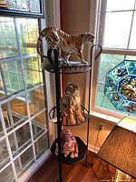 Three ceramic tiger figurines displayed on stand