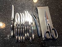 Group of Cutco knives, peeler and shears with box on countertop