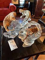 Wide shot of three porcelain big cat figures on crystal bases