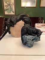 Front view showing both panther sculptures and their bases