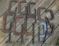 Top-down view of all 10 clamps laid out on wooden deck
