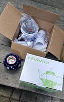 All three items — teapot box, ceramic warmer, open box of cutter parts