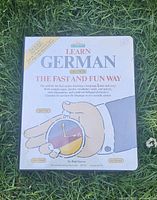 Front cover of Barron's Learn German course set placed on grass