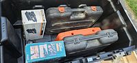 View inside Stanley chest showing boxed finishing sander, Black & Decker cases, orange accessory case