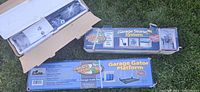 Three boxed Garage Gator products on grass