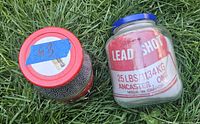 Top view of two jars; red-lidded jam jar full of lead pellets, blue-lidded jar holding cloth bag