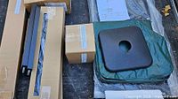 Overall view of boxed components, metal poles, square base covers and instruction sheet