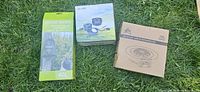 Three boxed items: solar camp shower 40L, AL-300 cookware set, RBSM LED fan/lamp