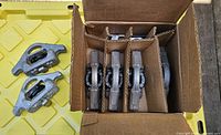 Opened box showing five cleats packed and one cleat pair outside plus hardware