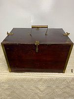 Front and side view of wooden box with brass corners and latch