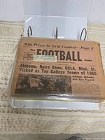 Binder open showing Football News issue front page