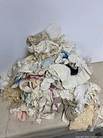Pile of assorted doilies, lace trims and linens