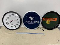 Group shot of wall clock, Moosehead sign, and Jägermeister tray