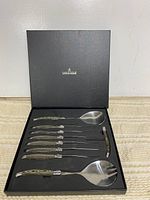 Set in open presentation box showing all nine pieces