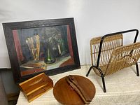 Group shot of painting, cedar box, teak plate and tongs, wicker magazine rack