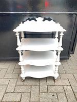 Front view of four-tier étagère showing shelves and crest