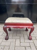 Front view showing carved cabriole legs, shell apron, claw feet and upholstered seat