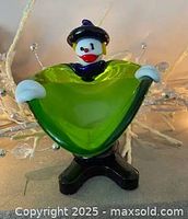 Front view of clown figurine showing green body and white hands